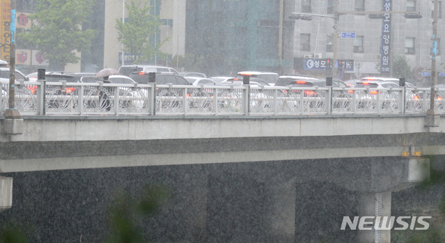 [전주=뉴시스]김얼 기자 = 전북지역에 새벽부터 비가 내리기 시작한 11일 전주시 덕진구 백제교 위를 지나는 한 시민이 우산으로 비를 피하며 길을 지나고 있다. 2021.05.11. pmkeul@newsis.com