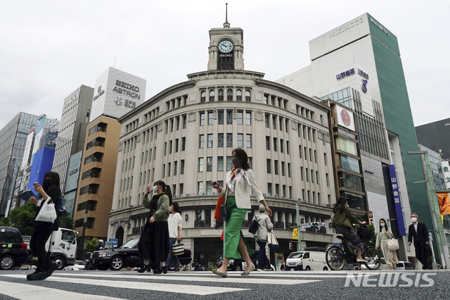 [도쿄=AP/뉴시스]11일 일본 도쿄에서 코로나19 확산 방지를 위해 마스크를 쓴 시민들이 긴자 쇼핑가를 건너고 있다. 도쿄도는 11일 925명의 코로나19 신규 확진자가 나온 것으로 확인됐다. 2021.05.11.
