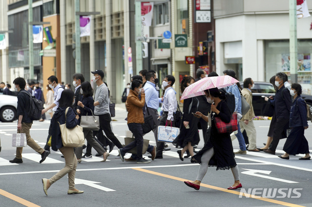 [도쿄=AP/뉴시스]12일 일본 도쿄에서 코로나19 감염 예방을 위해 마스크를 착용한 시민들이 횡단보도를 건너고 있다. 2021.05.12.