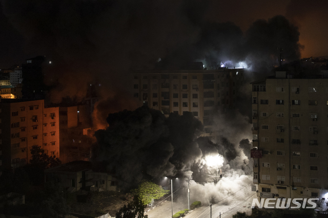 [가자=AP/뉴시스]12일 가자지구에서 이스라엘 측 공습을 받아 주거 건물에서 연기가 피어오르고 있다. 2021.05.12. 