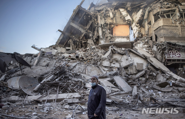  [가자지구=AP/뉴시스]13일(현지시간) 팔레스타인 가자 지구에서 한 남성이 이스라엘의 공습으로 무너진 건물을 바라보고 있다. 2021.05.13. 