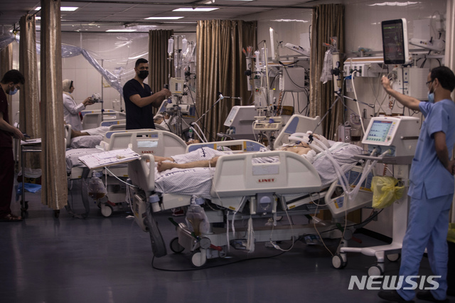 [가자지구=AP/뉴시스]13일(현지시간) 팔레스타인 가자 지구의 시파 병원 중환자실에서 이스라엘의 공습으로 다친 사람들이 치료받고 있다. 급증하는 코로나19로 어려움을 겪던 열악한 의료 시스템의 의료진은 이스라엘 공습에 따른 폭발과 파편에 의한 부상, 절단 등의 환자를 돌봐야 하는 이중고를 겪고 있다. 2021.05.14.