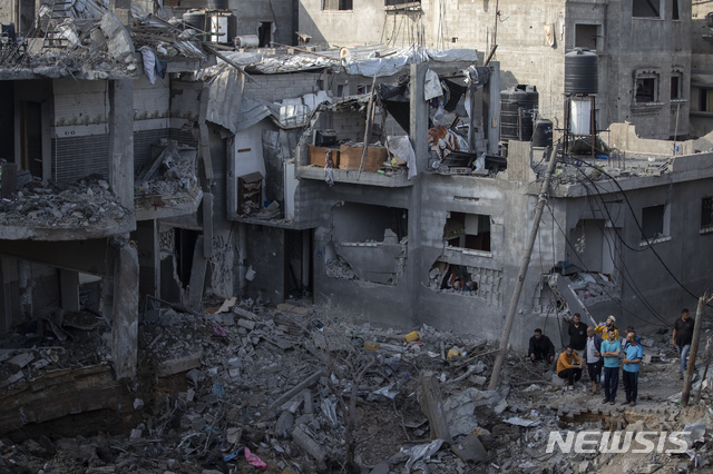 [가자지구=AP/뉴시스]지난 14일(현지시간) 팔레스타인 가자 지구 북부의 베이트 하노운 마을에서 주민들이 지난밤 이스라엘의 공습으로 파괴된 집들을 바라보고 있다. 2021.05.15.