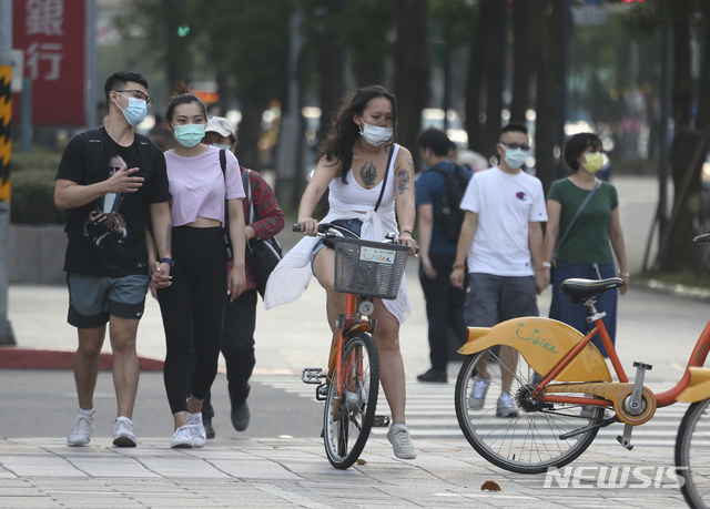[타이베이=AP/뉴시스] 15일 대만 수도에서 코로나19 경보 3가 발령된 가운데 사람들이 마스크를 꼭 착용하고 있다 