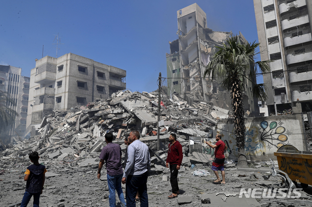 [가자시티=AP/뉴시스] 16일 이스라엘 공습을 받는 3개 거주건물 중 한 곳인 야제지 빌딩 앞에 사람들이 모여있다