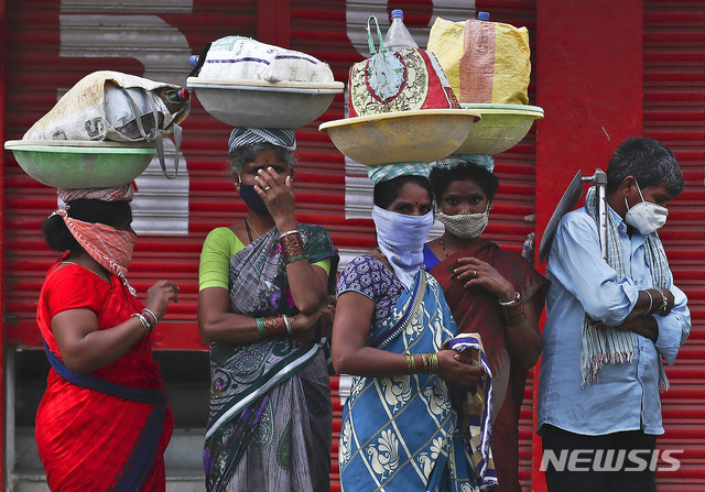 [하이데라바드=AP/뉴시스] 16일 인도 일용여성 근로자들이 마스크를 쓰고 차편을 기다리고 있다 