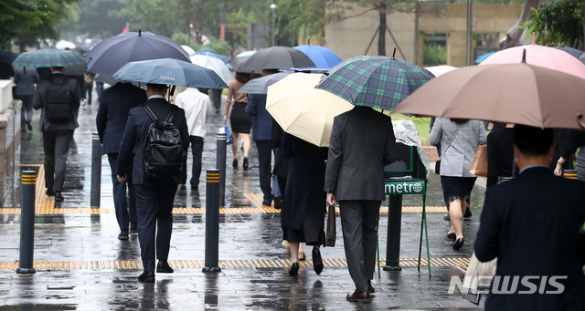 [서울=뉴시스]이영환 기자 = 이슬비가 내리고 있는 17일 오전 서울 영등포구 여의도역 인근에서 시민들이 우산을 쓰고 걸어가고 있다. 2021.05.17. 20hwan@newsis.com