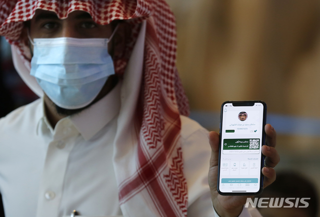 [지다(사우디아라비아)=AP/뉴시스]지난 5월17일(현지시간) 사우디아라비아 지다 소재 킹 압둘아지즈 국제공항 검문소에서 한 남성이 휴대전화로 코로나19 백신 접종 증명서를 보여주고 있다. 2021.07.29.