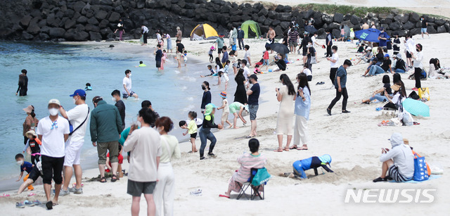 [제주=뉴시스]우장호 기자 = 맑은 날씨를 보인 18일 오후 제주시 조천읍 함덕해수욕장을 찾은 관광객들이 즐거운 시간을 보내고 있다. 2021.05.18. woo1223@newsis.com