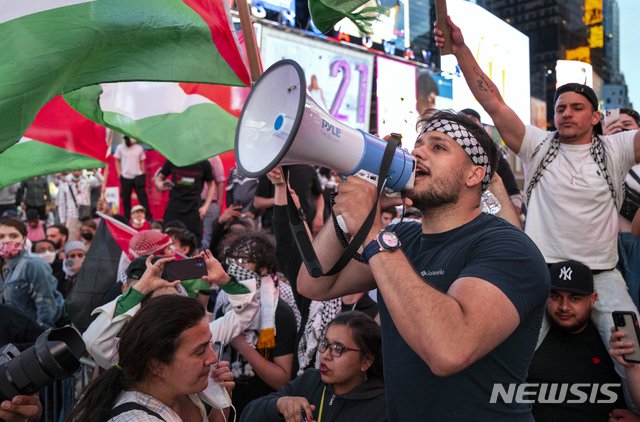 [뉴욕=AP/뉴시스]20일(현지시간) 미국 뉴욕에서 팔레스타인 지지자들이 팔레스타인 깃발을 들고 구호를 외치며 행진하고 있다. 이스라엘과 하마스는 11일간의 치열했던 분쟁을 종식하는 휴전을 선언했다. 2021.05.21.