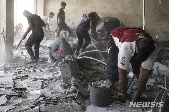 [가자=AP/뉴시스] 23일 휴전 사흘째인 가자 지구 베이트 라히아에서 청소년들이 공습파괴 건물을 치우고 있다