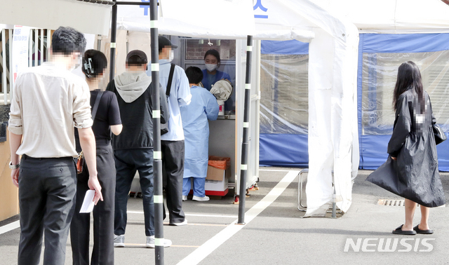 [서울=뉴시스]최진석 기자 = 코로나19 신규 환진자가 538명 발생한 24일 서울 중구 국립중앙의료원 선별진료소에서 사람들이 코로나19 검사를 위해 줄지어 대기하고 있다. 평일 대비 검사량이 감소하는 주말 영향으로 확진자 수는 이틀째 500명대다. 600명대 초반이었던 지난주 같은 기간에 비해 줄었지만, 400명대 중후반이었던 4월 말~5월 초보다는 많다.2021.05.24. myjs@newsis.com