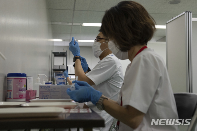 [도쿄=AP/뉴시스]지난달 24일 일본 도쿄에 새롭게 문을 연 코로나19 대규모 접종센터에서 의료진이 백신 접종 준비를 하고 있다.  2021.06.04.