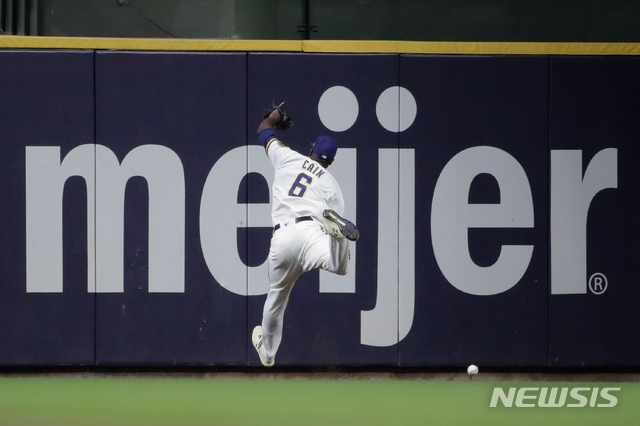 Milwaukee Brewers&#039; Lorenzo Cain is unable to catch a triple hit by San Diego Padres&#039; Ha-Seong Kim during the seventh inning of a baseball game Wednesday, May 26, 2021, in Milwaukee. (AP Photo/Aaron Gash)