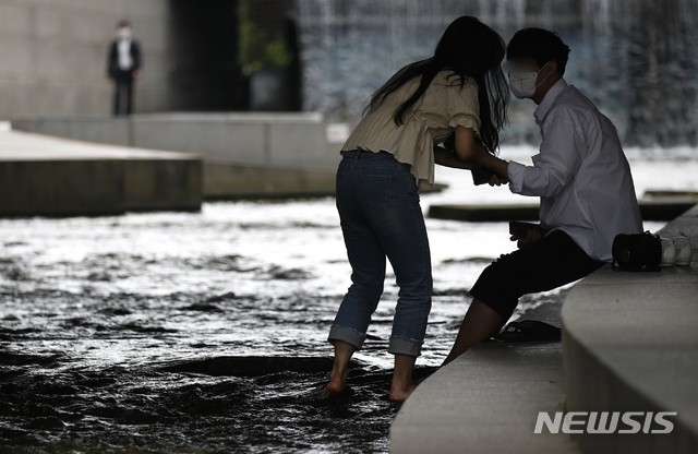 [서울=뉴시스]정병혁 기자 = 서울 낮 최고기온이 30도까지 오르는 등 더운 날씨가 이어지고 있는 10일 서울 중구 청계천에서 시민들이 물에 발을 담그고 있다. 2021.06.10. jhope@newsis.com