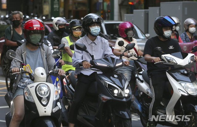[타이베이=AP/뉴시스] 대만 수도 타이베이에서 11일 코로나19 예방을 위해 마스크를 착용한 시민들이 오토바이와 스쿠터를 몰고 도로를 주행하고 있다. 2021.06.13