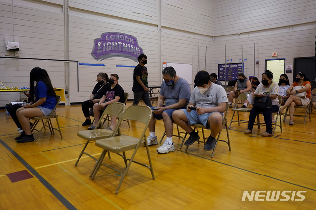 [AP/뉴시스] 11일 미국 일리로이주 휠링에서 학생들과 그 부모들이 화이자 백신 2차 주사를 맞은 후 의자에 나란히 앉아 있다
