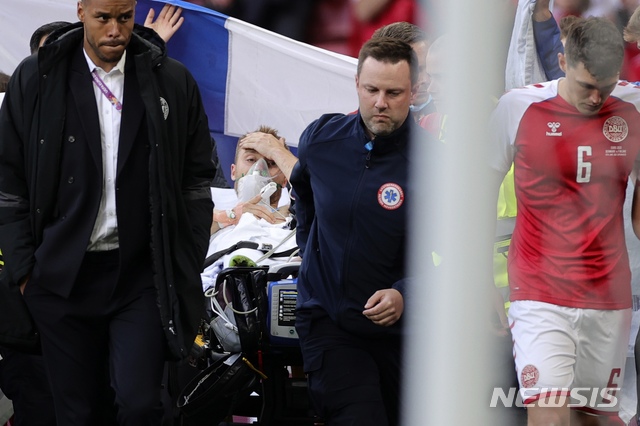 Paramedics using a stretcher to take out of the pitch Denmark&#039;s Christian Eriksen after he collapsed during the Euro 2020 soccer championship group B match between Denmark and Finland at Parken stadium in Copenhagen, Denmark, Saturday, June 12, 2021. (Friedemann Vogel/Pool via AP)