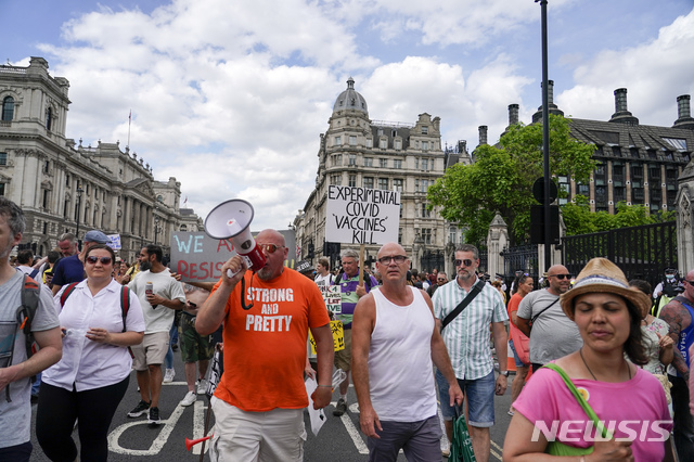 [런던=AP/뉴시스]14일(현지시간) 영국 런던의 웨스트민스터 궁 앞에서 코로나19 봉쇄 해제 연기에 대한 항의 시위가 열려 시위대가 구호를 외치며 행진하고 있다. 보리스 존슨 영국 총리는 코로나19 변이 바이러스 '델타'가 확산하면서 애초 이달 21일 해제하려던 봉쇄조치를 7월 19일로 4주간 연기한다고 밝혔다. 2021.06.15.