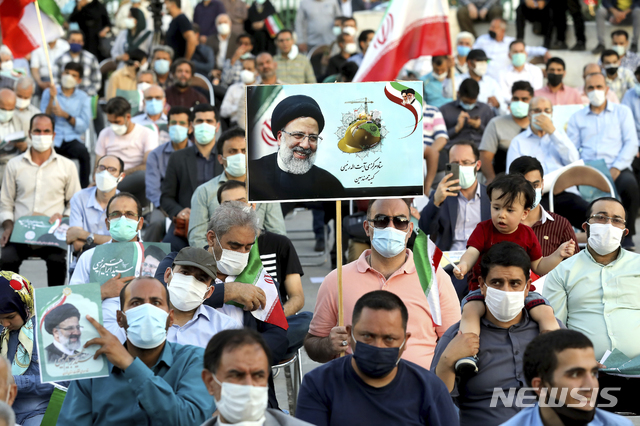 [테헤란=AP/뉴시스]에브라힘 라이시 이란 대통령 후보 지지자들이 14일(현지시간) 테헤란에서 열린 선거 유세에 참석해 그의 서명이 담긴 사진을 들고 있다. 강경 보수 성향 성직자인 라이시 후보는 최근 이란 국영 TV가 진행한 대선 여론조사에서 압도적으로 1위를 기록했다. 이란 대선은 오는 18일 치러진다. 2021.06.15.