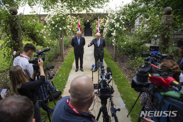 [런던=AP/뉴시스] 영국의 존슨 총리(오른쪽)와 호주의 모리슨 총리가 총리관저 정원에서 자유무역협정의 기본틀을 언론에 공표하고 있다