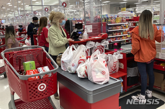 A customer wears a mask as she waits to get a receipt at a register in a Target store in Vernon Hills, Ill., Sunday, May 23, 2021. Retail sales fell in May, dragged down by a decline in auto sales, likely due to fewer cars being made amid a pandemic-related shortage of chips. Sales dropped a seasonal adjusted 1.3% in May from the month before, the U.S. Commerce Department said Tuesday, June 15. (AP Photo/Nam Y. Huh)