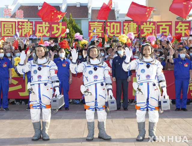 [주취안=신화/뉴시스]17일(현지시간) 중국 간쑤성 주취안의 주취안 위성발사센터에서 선저우 12호 탑승 우주인 환송식이 열려 우주비행사 탕훙보, 류보밍, 니하이성(왼쪽부터)이 손을 흔들고 있다. 2021.06.17.