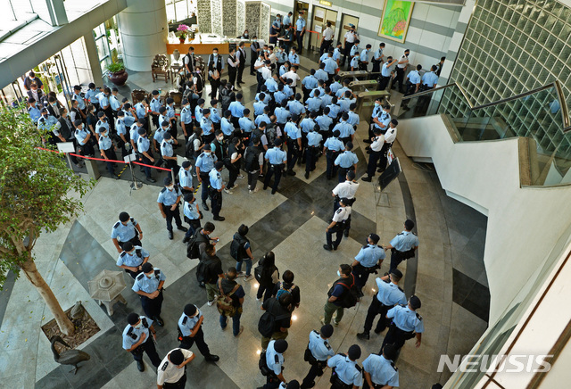 [홍콩=AP/뉴시스]17일 홍콩 대표적 반중매체 빈과일보 본사 건물에서 경찰관들이 모여있다. 경찰은 이날 라이언 로 편집장을 체포하고 본사를 급습해 증거자료를 압수했다. 2021.06.21.