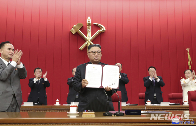 [평양=AP/뉴시스]지난 17일 김정은 북한 조선노동당 총비서 겸 국무위원장이 당 중앙위원회 8기 3차 전원회의 3일 차 회의 중 자신이 서명한 문서를 들어 보이고 있다. 2021.06.18.