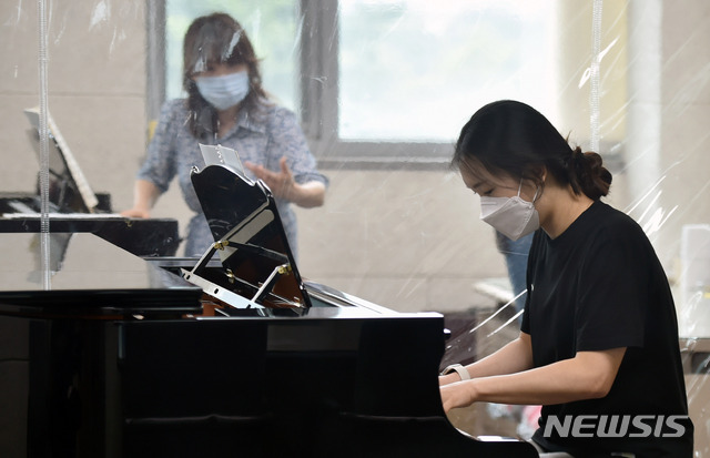 [경산=뉴시스]이무열 기자 = 대학교 2학기 대면수업 확대 방안이 논의되고 있는 가운데 22일 오후 경북 경산 대구가톨릭대학교 음악대학에서 한 학생이 비닐 장막을 사이에 두고 피아노 실기수업을 받고 있다. 2021.06.22. lmy@newsis.com