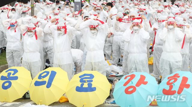 [세종=뉴시스]강종민 기자 = 전국보건의료산업노조가 23일 오후 세종시 어진동 정부세종청사 보건복지부 앞에서 열린 2021 보건의료노조 총파업투쟁 선포 결의대회에서 '공공의료 확충', '보건의료인력 확충' 등을 촉구하며 방호복 퍼포먼스를 벌이고 있다. 2021.06.23. ppkjm@newsis.com