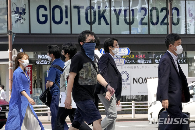[도쿄=AP/뉴시스] 지난 6월25일 일본 도쿄 풍경. 뒤편에 도쿄올림픽 홍보 문구가 보인다. 2021.07.01.