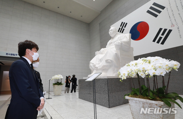 [서울=뉴시스]이영환 기자 = 이준석 국민의힘 대표가 백범 김구 선생 서거 72주기인 26일 오전 서울 용산구 김구 선생 묘역을 찾아 참배를 마친 후 기념관을 찾아 김구 선생 좌상과 김구 서명 태극기를 살펴보고 있다. 2021.06.26. 20hwan@newsis.com