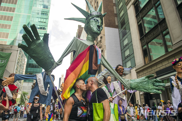 [뉴욕=AP/뉴시스]27일(현지시간) 미국 뉴욕에서 퀴어(성소수자) 해방 행진이 열려 행진에 참가한 한 동성 부부가 프라이스 조형물 앞에서 키스하고 있다. 사진은 기사와 직접 관련 없음. 2021.06.28.