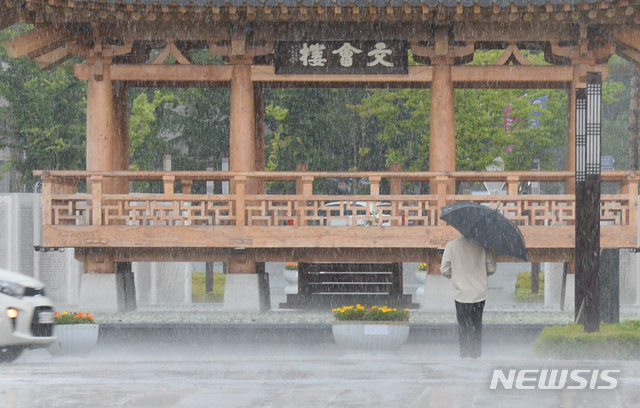 [전주=뉴시스]김얼 기자 = 전북 전주시에 소나기와 더불어 우박이 내리기 시작한 지난 28일 전북대학교에서 학생이 비를 피하며 교정을 지나고 있다. 2021.06.28. pmkeul@newsis.com