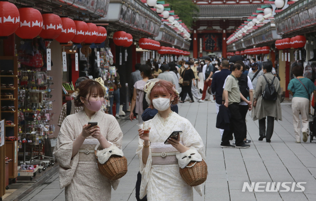 [도쿄=AP/뉴시스]지난달 30일 일본 도쿄에서 코로나19 확산 방지를 위해 마스크를 쓴 여성들이 기모노를 입고 아사쿠사 지역을 걷고 있다. 2021.07.08.