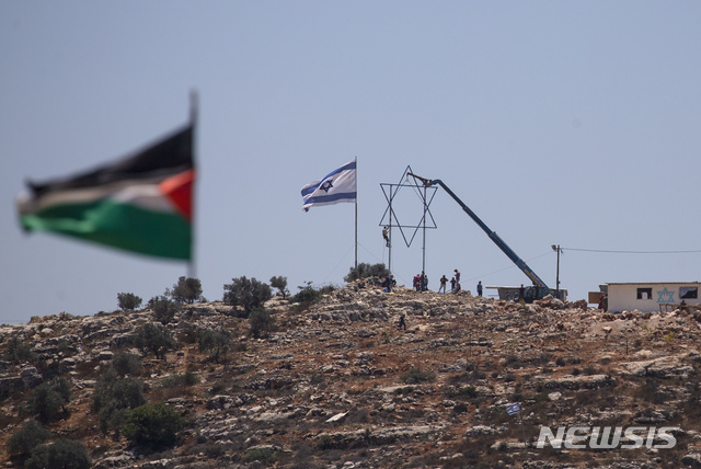 [서안지구=AP/뉴시스]요르단강 서안지구에 공존하는 이스라엘 국기와 팔레스타인 국기. 2021.07.05.photo@newsis.com