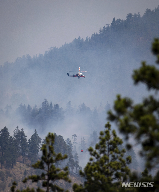 [AP/뉴시스]역대급 폭염으로 산불이 난 캐나다 브리티시 콜럼비아주 리튼에서 헬기가 산불진화용 물을 운반하고 있다. 