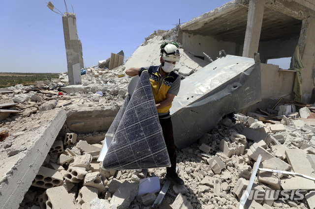 [이들리브(시리아)=AP/뉴시스]지난 3일 '화이트 헬멧'으로 불리는 구조대원이 시리아 북서부 이들리브 주(州) 이블린 마을에서 정부군 폭격으로 붕괴된 주택을 조사하고 있다. 2021.07.24.photo@newsis.com