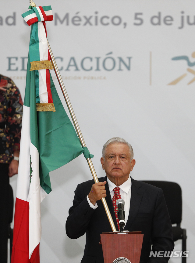 [멕시코시티=AP/뉴시스]안드레스 마누엘 로페스 오브라도르 멕시코 대통령이 5일(현지시간) 멕시코시티에서 열린 멕시코 올림픽 선수단의 2020 도쿄올림픽 출정식에 참석해 선수단에 건넬 국기를 들고 있다. 2021.07.06.