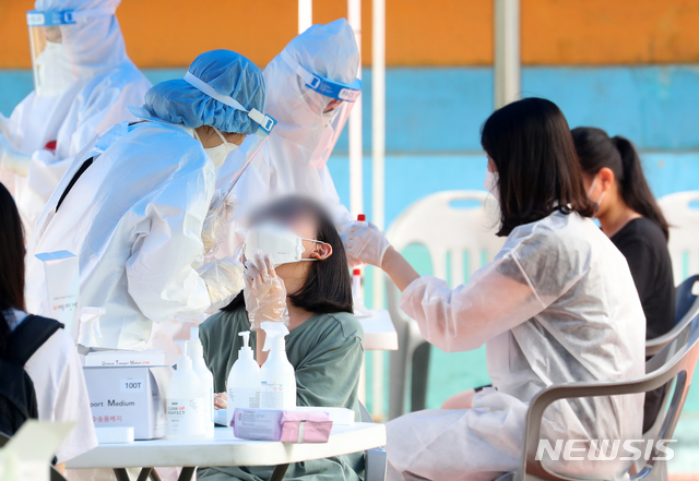 [인천=뉴시스]배훈식 기자 = 초등학생 코로나19 집단 감염이 발생한 6일 오전 인천 미추홀구 인주초등학교에 마련된 워크스루(Walk Through) 선별 진료소를 찾은 학생과 학부모, 가족들이 검사를 받고 있다. 2021.07.06. dahora83@newsis.com