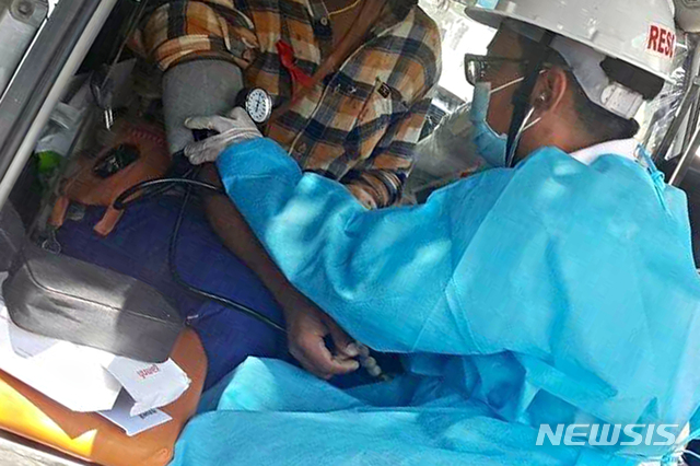 [양곤(미얀마)=AP/뉴시스]지난 3월5일 시위 중 부상을 입은 환자를 돌보고 있는 의료진의 모습. 2021.07.06.photo@newsis.com