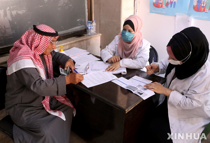 [ 하사카( 시리아)= 신화/뉴시스] 시리아 북동부의 하사카주에서 지난 해 7월 의료진들이 주민에게서 백신접종 신청을 받고 있다. 