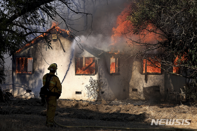 [레드우드밸리=AP/뉴시스] 7일(현지시간) 미 캘리포니아주 레드우드밸리에서 소방관들이 불길에 휩싸인 한 주택의 화재를 진압하고 있다. 캘리포니아 전역에 덥고 건조한 날씨가 이어질 것으로 예보됐으며 소방관들은 이로 인해 여러 곳에서 발생한 산불과 싸우고 있다. 2021.07.09.