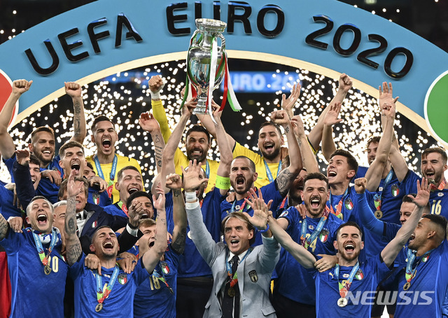 Italy&#039;s team celebrates with the trophy on the podium after winning the Euro 2020 soccer championship final between England and Italy at Wembley stadium in London, Sunday, July 11, 2021. (Michael Regan/Pool via AP)