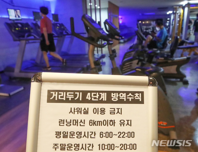 [서울=뉴시스] 조수정 기자 = 사회적 거리두기 4단계 첫날인 지난 12일 서울 은평구 연신내 한 헬스장에서 회원들이 런닝머신 등 기구를 이용하고 있다. 헬스장에서는 샤워실을 이용할 수 없고 런닝머신은 시속 6km이하의 속도를 유지해야 한다. 2021.07.12. chocrystal@newsis.com