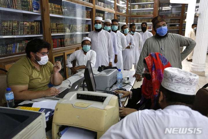 [라호르=AP/뉴시스]지난해 7월12일(현지시간) 파키스탄 라호르 지역에 설치된 백신접종센터에서 의료진들이 중국의 코로나19 백신 콘비데시아를 접종하기 위해 명단을 등록하고 있다. 2022.05.19.