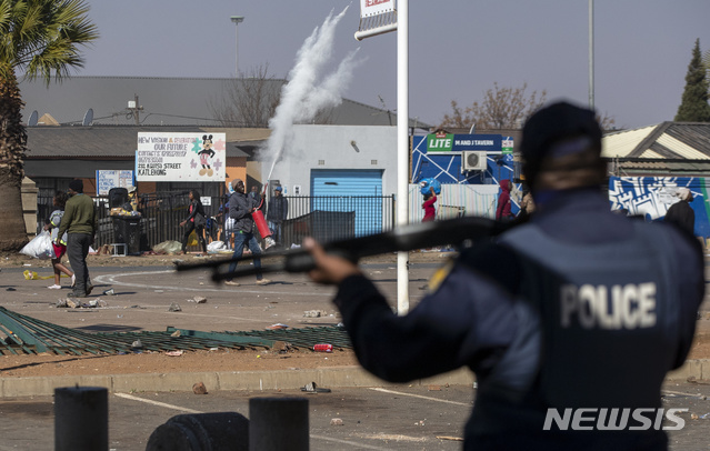 [요하네스버그=AP/뉴시스] 12일(현지시간) 남아프리카공화국 요하네스버그에서 한 상점을 털려는 약탈범들이 경찰을 향해 돌을 던지고 있다. 경찰은 제이콥 주마 전 대통령의 수감 이후 폭동과 약탈이 고조되면서 6명이 숨지고 200명 이상이 체포됐다고 밝혔다. 2021.07.13.