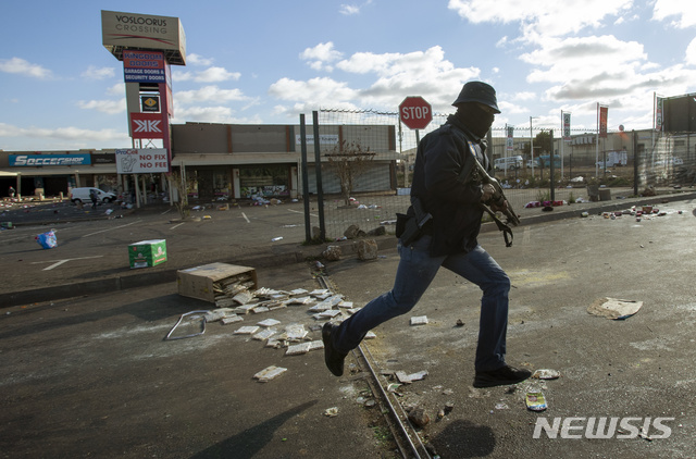 [요하네스버그=AP/뉴시스] 13일(현지시간) 남아프리카공화국 요하네스버그 인근 소웨토에서 한 지하철 직원이 약탈자들을 쫓고 있다. 2021.07.14.