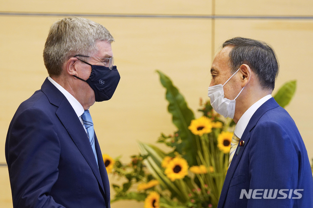 International Olympic Committee President Thomas Bach, left, meets Japanese Prime Minister Yoshihide Suga during his courtesy call at the latter&#039;s official residence in Tokyo Wednesday, July 14, 2021. (Kimimasa Mayama/Pool Photo via AP)